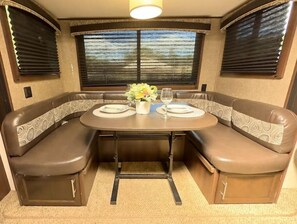 Cozy dining area with a round table and two cushioned benches, perfect for intimate meals.