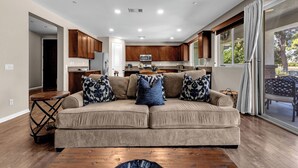 A modern kitchen with wooden cabinets, a microwave, and a dining area with a table and chairs. - Luxe Villa On Golf Course 🏌️~ Private Pool/Spa 🏊 ~EV Charger ~ Tennis (Indio)