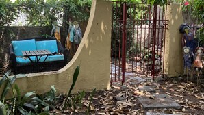 A garden area with a seating area, a gate, and a pathway. - 🌴Tropical Cottage, In The Lovely Palm Beach Historic District LOCATION!  (West Palm Beach)