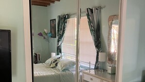 A bedroom with a bed, a dresser, a mirror, and a television. - 🌴Tropical Cottage, In The Lovely Palm Beach Historic District LOCATION!  (West Palm Beach)