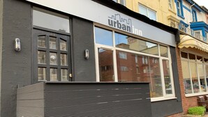 A building with a sign reading "urban inn" and a large window. - Urban Inn (Blackpool)