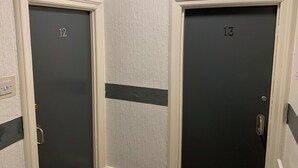 Two doors with numbers 12 and 13, white frames, and a textured wall. - Urban Inn (Blackpool)