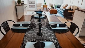 A dining area with a long wooden table set for four, a patterned runner, and a ceiling fan. - Perfect Family Vacation House (Pace)