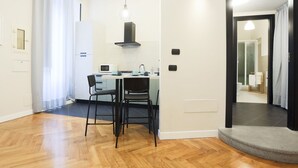 Une cuisine moderne avec un coin repas, un four à micro-ondes, une cuisinière et un évier.
