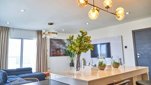 A modern living room with a sofa, a coffee table, and a decorative plant centerpiece. - Gallery by Cozy (Accra)
