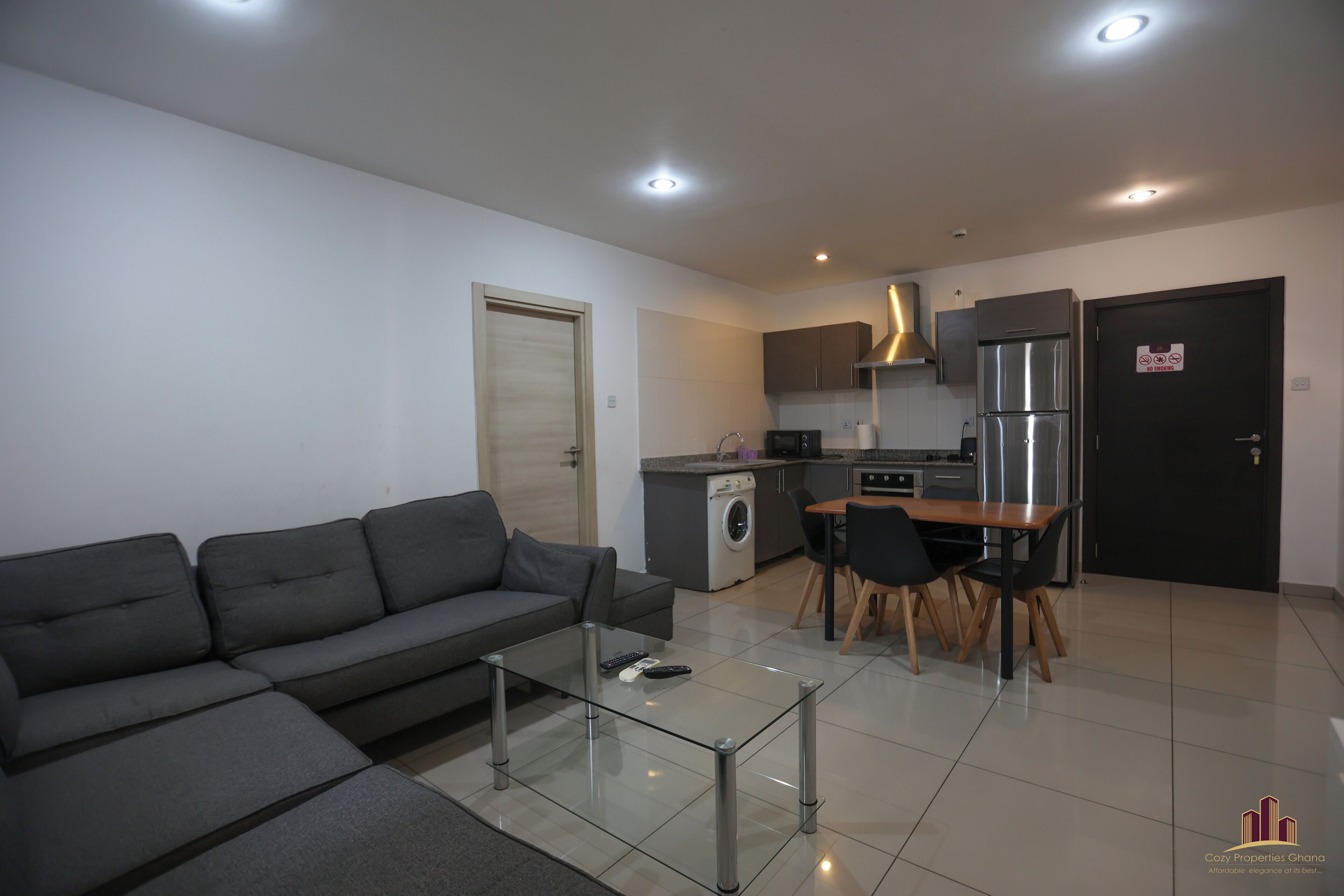 A modern apartment with a living room, kitchenette, and dining area.