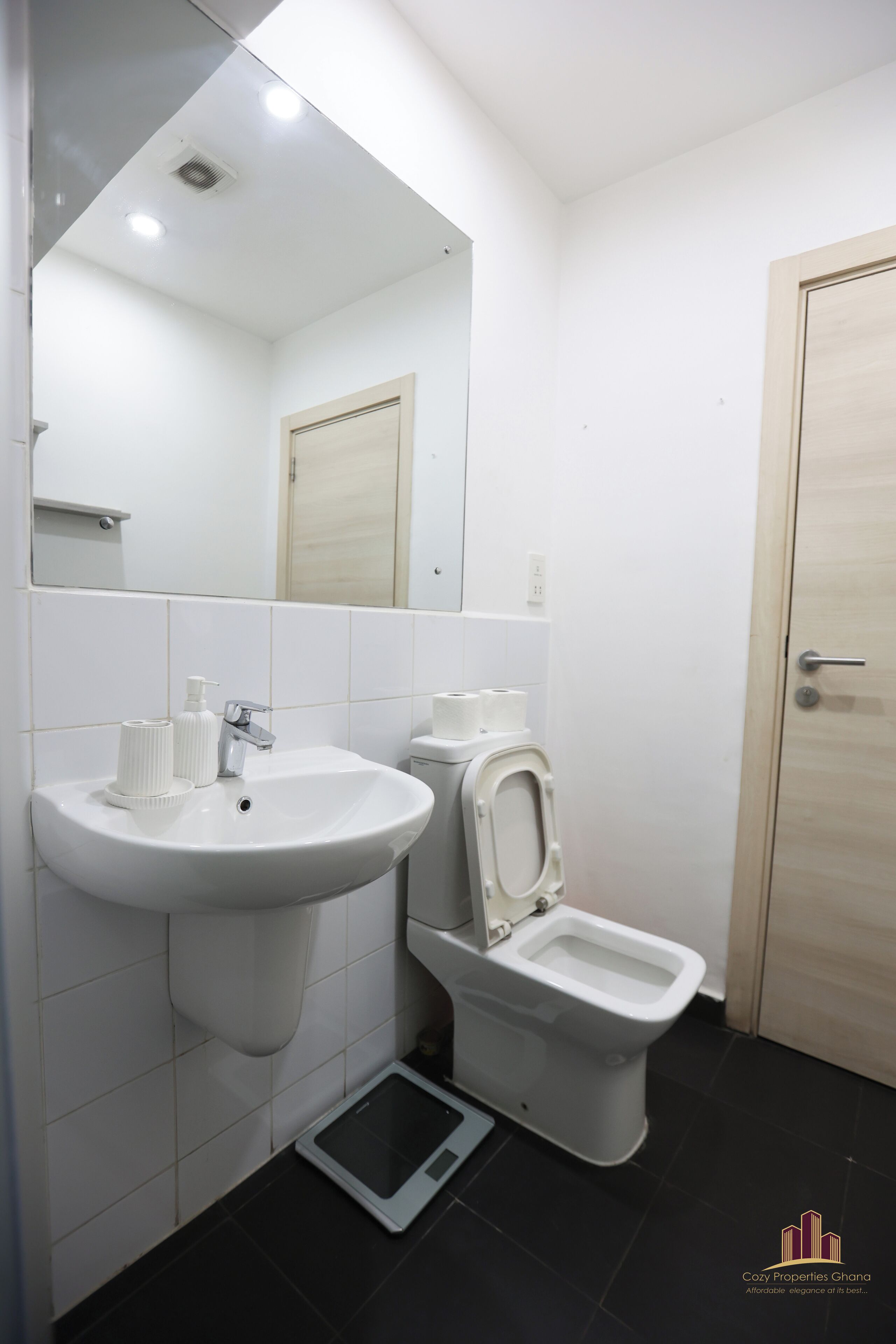 Un bagno con un lavandino bianco, un water e uno specchio.
