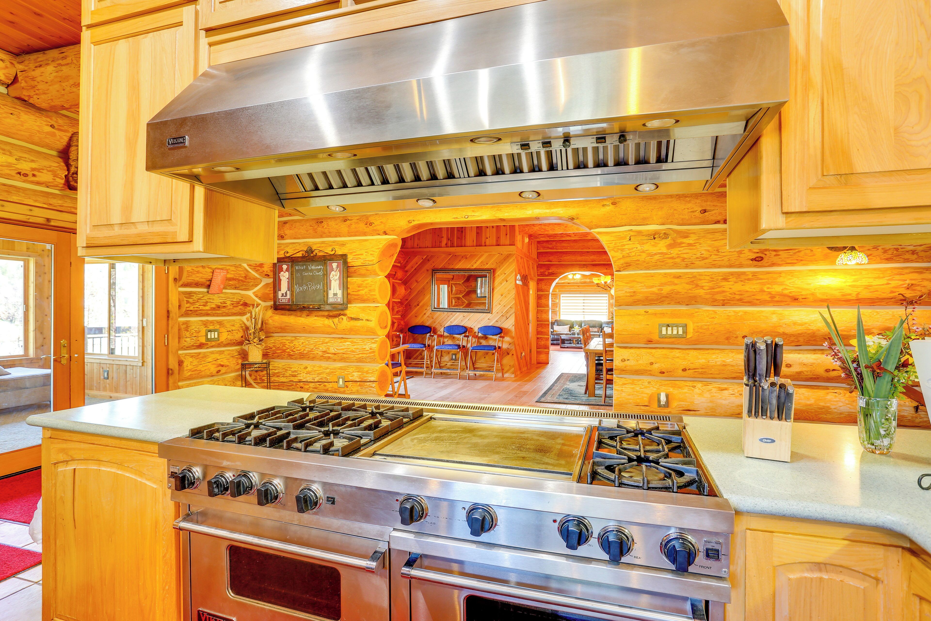 A kitchen with wooden cabinetry, a stainless steel range hood, and a gas stove.
