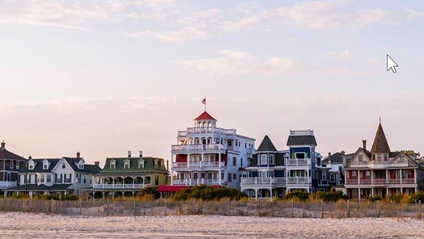 A beachfront property with multiple-story houses, a lighthouse, and a sandy beach. - 4 Blocks to Beach, Linens Provided (Cape May)