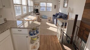A modern kitchen with white cabinets, a wooden countertop, and a dining area with a table and chairs. - 4 Blocks to Beach, Linens Provided (Cape May)