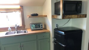 A compact kitchen with a sink, a toaster, a microwave, and a refrigerator. - Newly Restored Vintage Cabin near Bryce, Grand Staircase. Great views! (Henrieville)