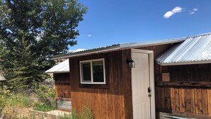A small wooden cabin with a metal roof, a door, and a window. - Newly Restored Vintage Cabin near Bryce, Grand Staircase. Great views! (Henrieville)