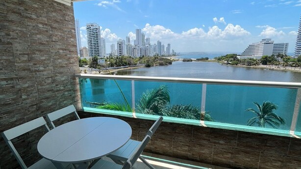 Varanda com vista para o horizonte urbano e um corpo de água.