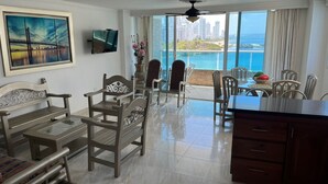 Ampla sala de estar com varanda e vista para a cidade e para a água.