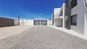 Un edificio moderno con un camino de grava que conduce a una entrada con puerta de acceso.
