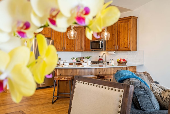 A kitchen with wooden cabinets, a microwave, and a sink.