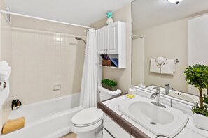 Ein Badezimmer mit Badewanne, Toilette, Waschbecken und Spiegel.