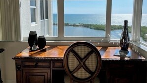 A desk with a view of the ocean through a large window. - St. Nicole Condo in Pelican Bay, Naples, Florida with Gorgeous Gulf Views (Naples)