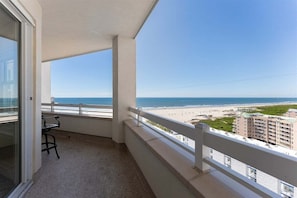 Een balkon met uitzicht op het strand en de oceaan.
