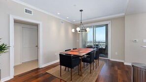 A dining area with a table, chairs, and a view to the outside.