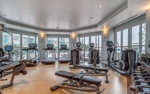 Een ruime fitnessruimte met loopbanden, krachtapparaten en gewichten.