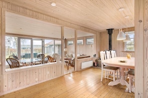 Una habitación con paneles de madera, una mesa de comedor, sillas y un banco.