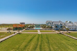 Une station balnéaire dotée d’une piscine, de plusieurs villas et d’une pelouse bien entretenue.