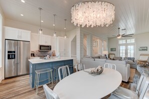 A modern kitchen with a central island, stainless steel appliances, and pendant lighting.