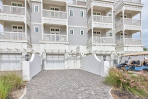A multi-story building with a gated driveway and a golf cart parked nearby.