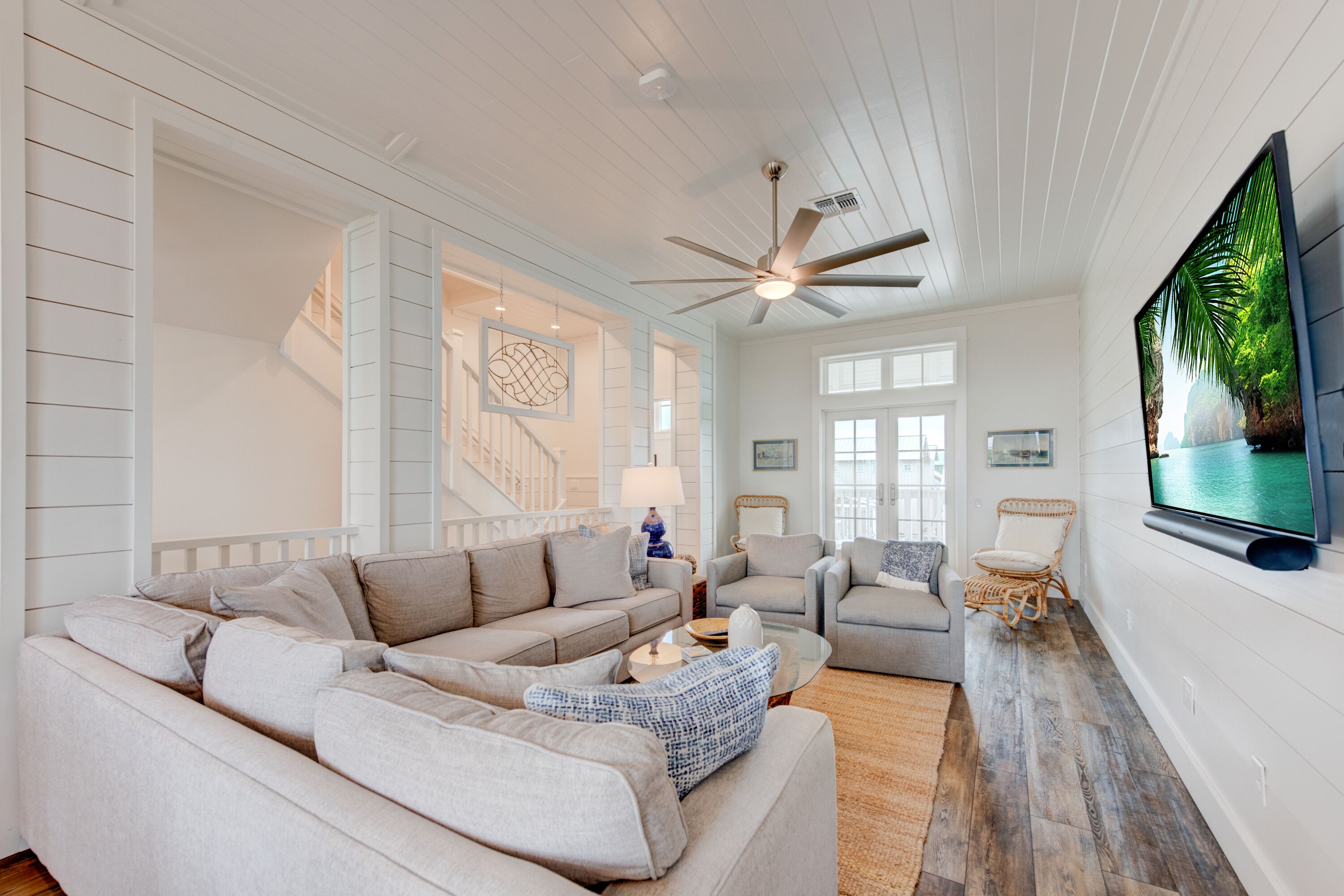 A spacious living room with a large sectional sofa, a coffee table, and a flat-screen TV mounted on the wall. - Rooftop Balcony, Boardwalk to Beach, Resort Pool (Port Aransas)