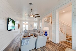 Relax in a spacious living area with a large sectional sofa and flat-screen TV, perfect for unwinding.