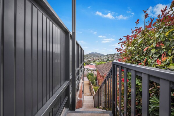 Stairway to scenic views, flanked by lush greenery and a metal railing.