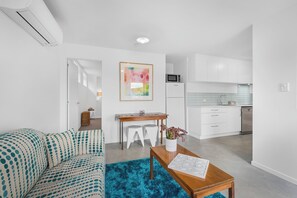 Relax in this stylish living space with a sofa, coffee table, and kitchen area.