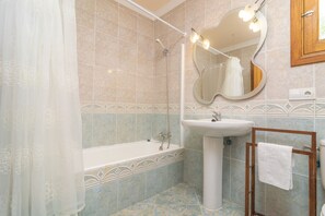 Tina con regadera, secadora de cabello, bidet, toallas 