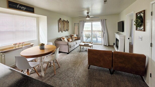 A living room with a sofa, coffee table, and dining area with chairs.