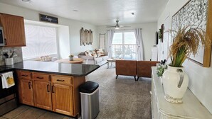A spacious kitchen with wooden cabinets, a central island, and a dining area with a bench.
