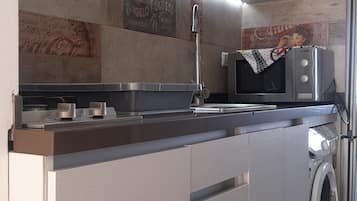 Una cocina moderna con electrodomésticos de acero inoxidable, horno empotrado y microondas.