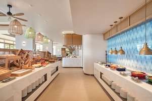 A buffet setup with various food items and a central island with a sink.