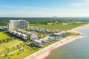 Een resort met meerdere gebouwen, een strand en een zwembad.