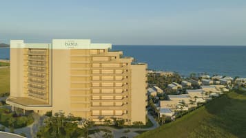 A high-rise hotel with multiple balconies and a view of the ocean.