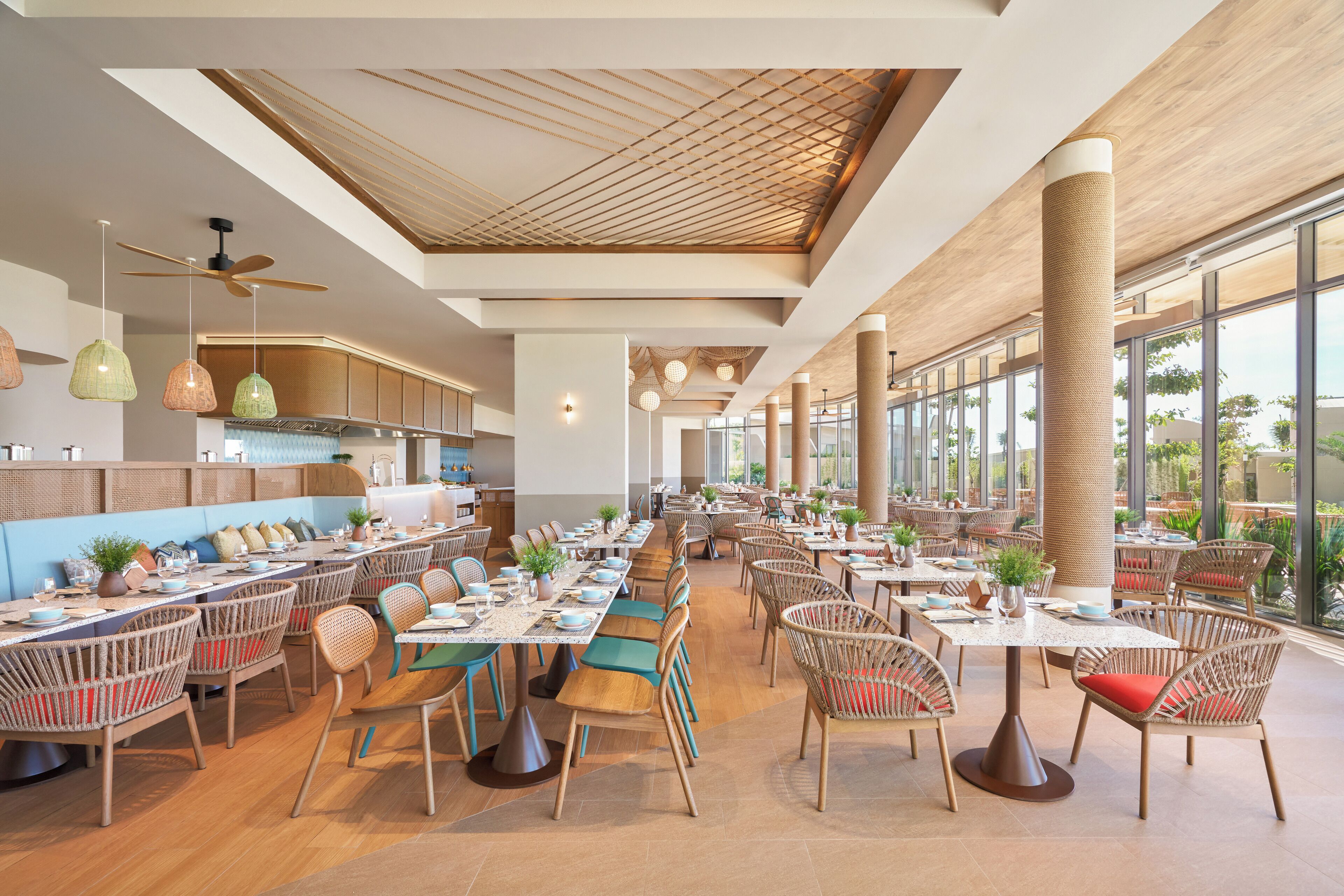 Un restaurant spacieux avec de hauts plafonds, de grandes fenêtres et différents types d’aménagements pour s’asseoir.