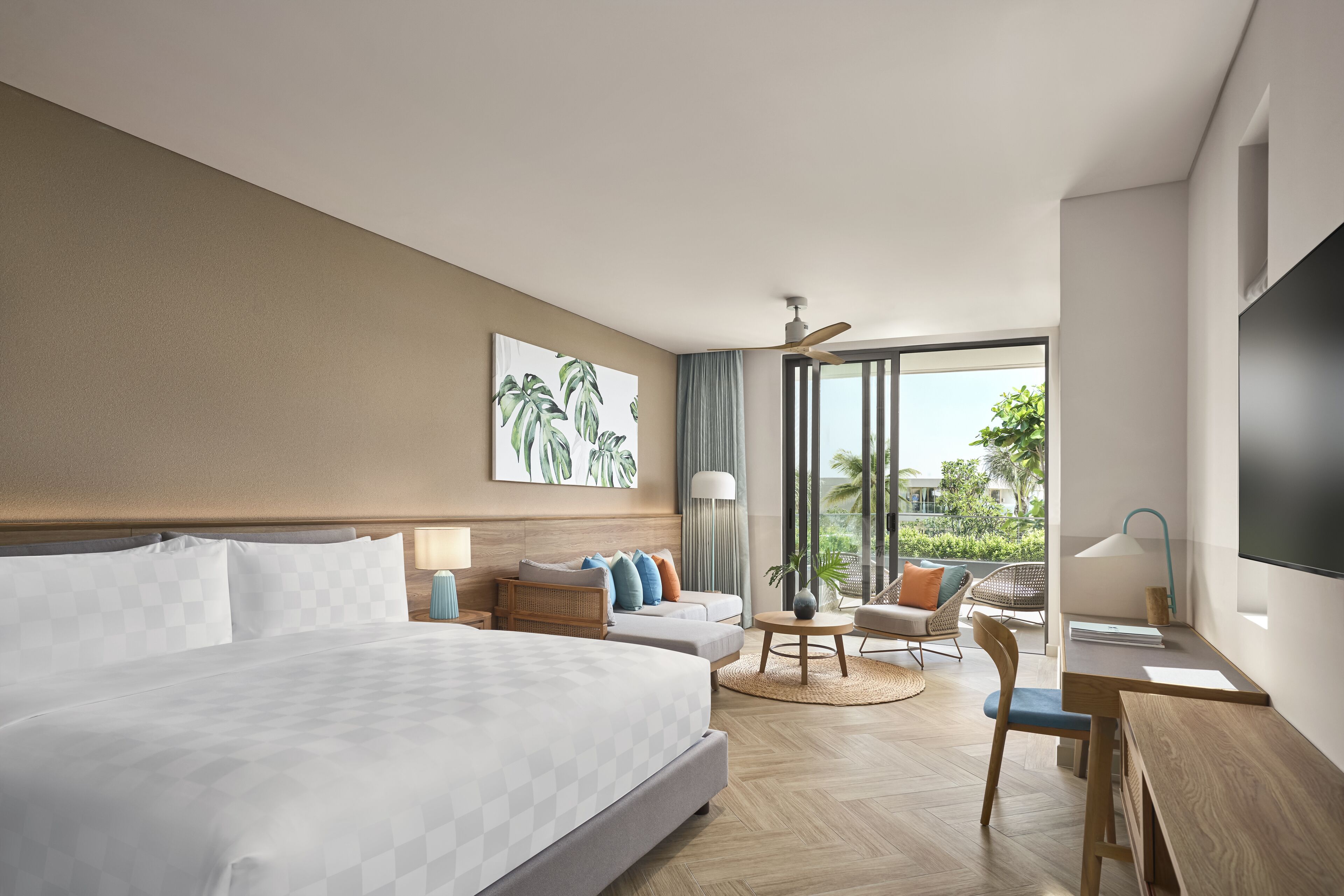 A modern hotel room with a large bed, a desk, a chair, and a view of the outdoors.