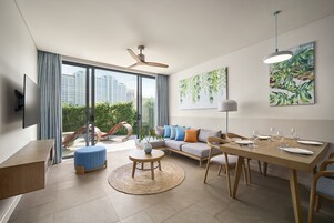 Una sala de estar moderna con sofá, mesa de comedor y televisor.