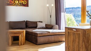 A modern living room with a brown leather sofa, a wooden coffee table, and a floor lamp. - Apartment "Südalb" with Shared Garden & Wi-Fi (Albstadt)