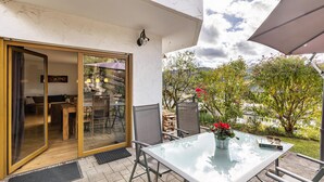 A patio with a glass table, chairs, and a potted plant. - Apartment "Südalb" with Shared Garden & Wi-Fi (Albstadt)