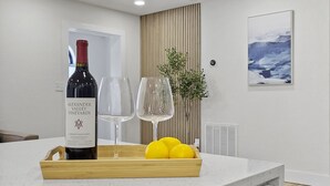 A modern kitchen with a white countertop, a wine bottle, two wine glasses, and a tray of lemons. - Wilderness Escape, by Breathtaking Natl Park (Tampa)