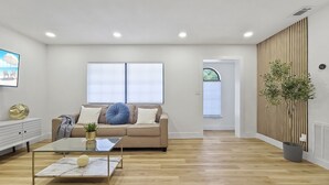 A modern living room with a sofa, a glass coffee table, and a potted plant. - Wilderness Escape, by Breathtaking Natl Park (Tampa)