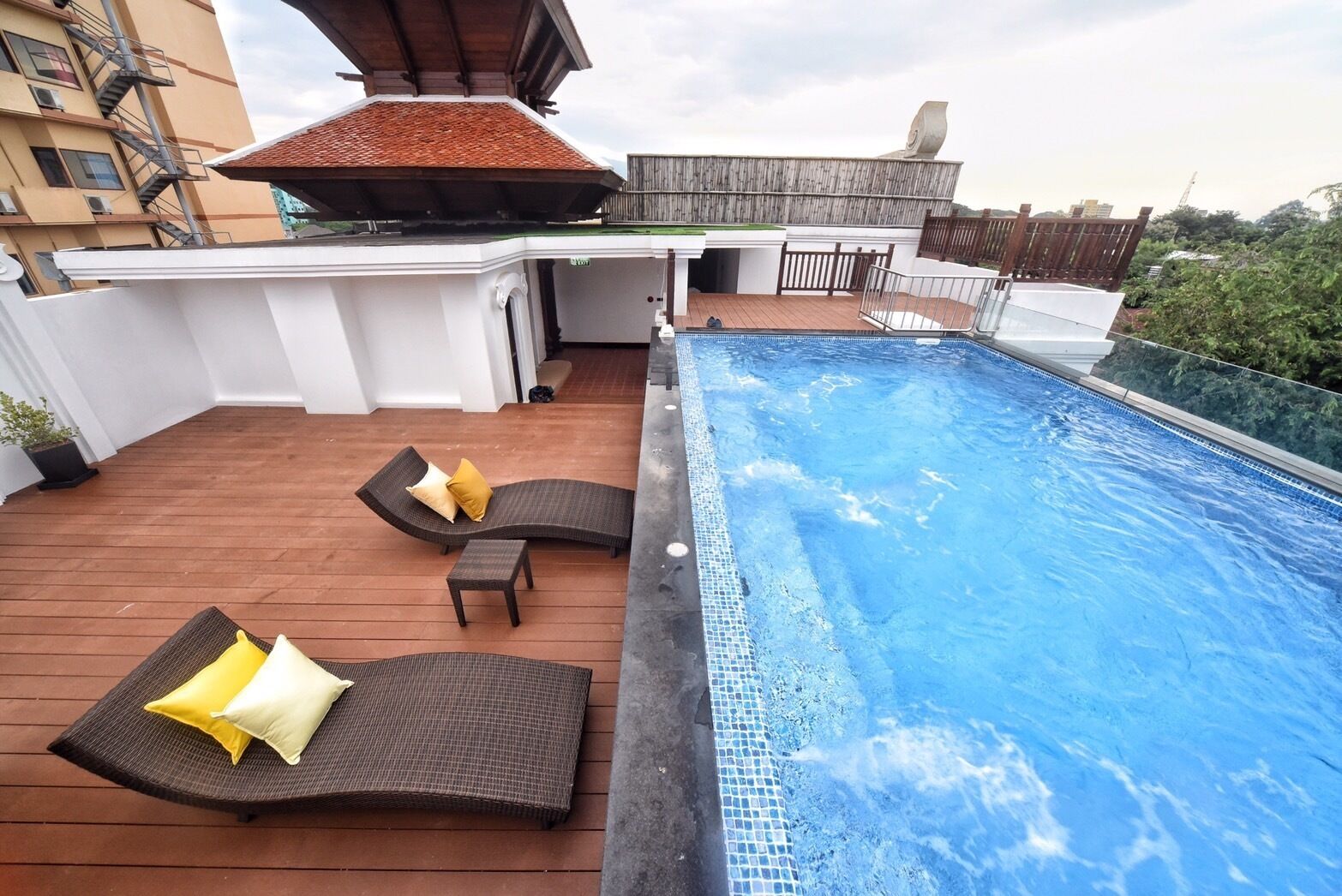 Un espace piscine aménagé sur le toit, avec des chaises longues et une petite table.