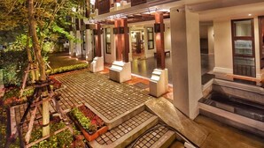 Hotel com vários andares e área externa coberta, incluindo piscina e área de estar.