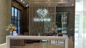A reception desk with a modern design, featuring a logo above the counter.